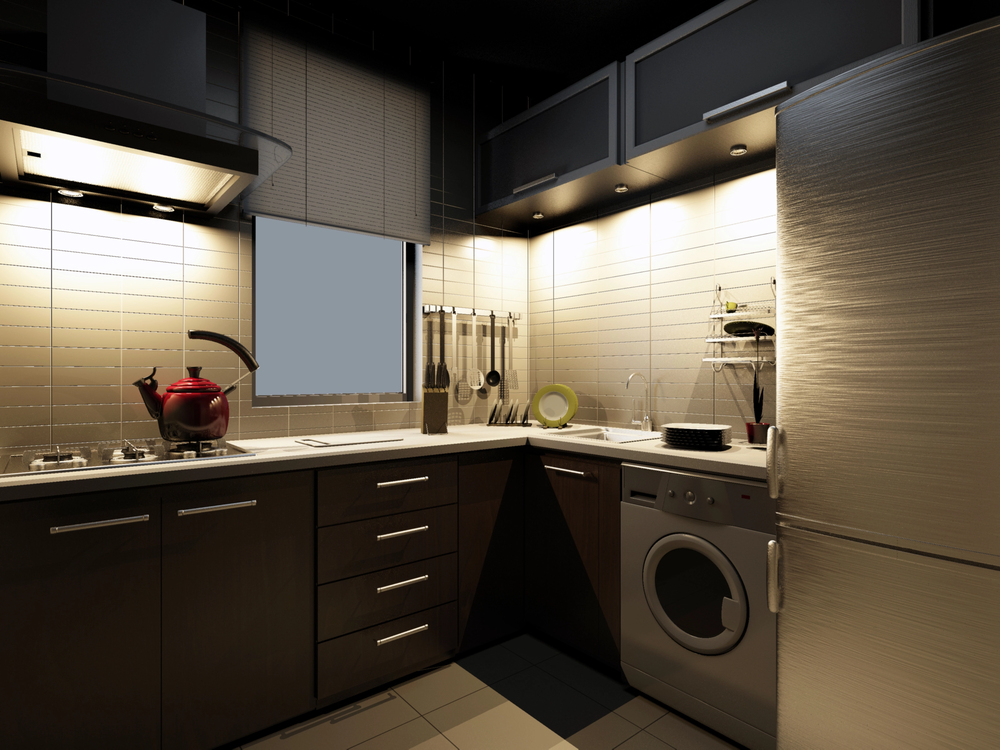 Modern kitchen with dark cabinets, a stove with a red kettle, a front-load washing machine, under-cabinet lighting professionally installed by an electrician, utensils hanging on the wall, and a window with closed blinds.